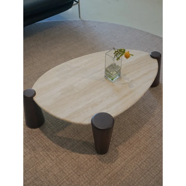 Island Travertine Coffee Table on Dark Wood Cylinder Legs in oatmeal — in a room setting