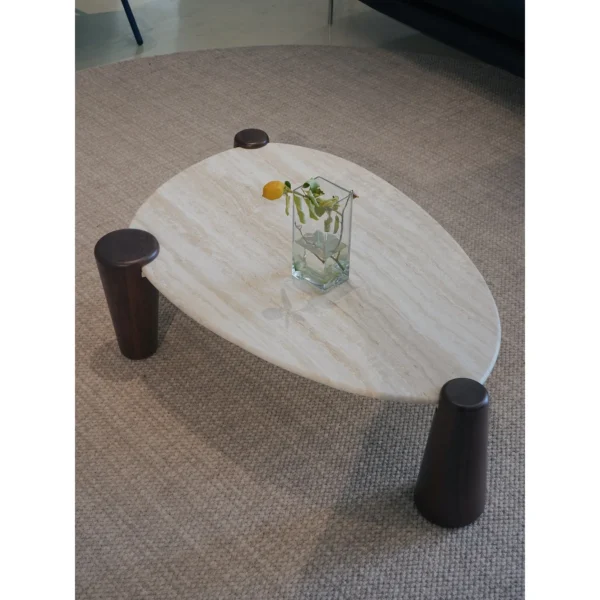 Island Travertine Coffee Table on Dark Wood Cylinder Legs in oatmeal — in a room setting