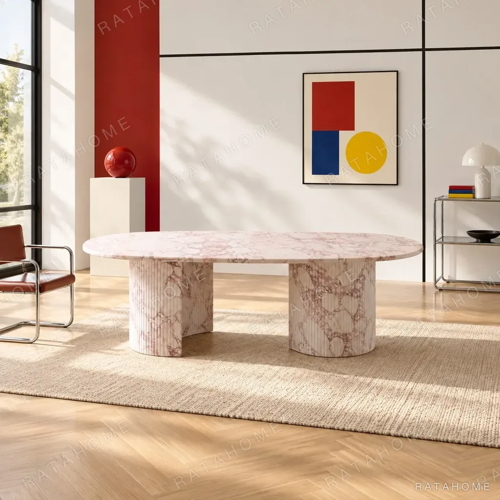 Pink Marble Oval Dining Table on Twin Stone Cylinders in rose stone — in a room setting