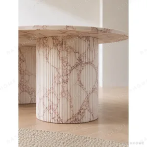 Pink Marble Oval Dining Table on Twin Stone Cylinders in rose stone — in a room setting