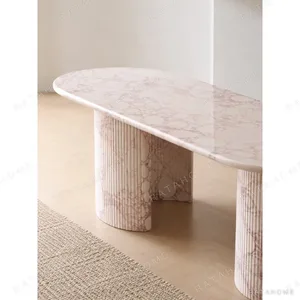 Pink Marble Oval Dining Table on Twin Stone Cylinders in rose stone — in a room setting