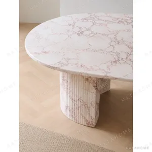Pink Marble Oval Dining Table on Twin Stone Cylinders in rose stone — in a room setting