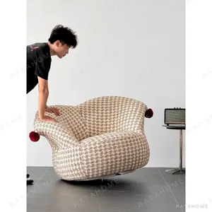 Clown Houndstooth Lounge Chair with Red Pompoms in sand — in a room setting