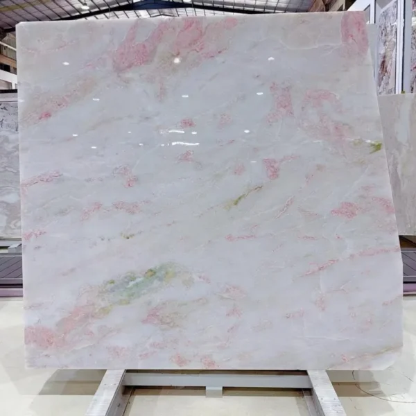 Soft Pink Marble Oval Dining Table on Column Legs in rose stone — in a room setting