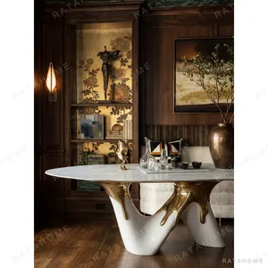 White Marble Table on Molten Gold Sculptural Base in ivory — in a room setting