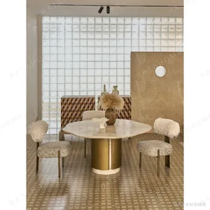 Four Seasons Pink Stone Wave-Edge Dining Table on Brass Base in rose stone — in a room setting