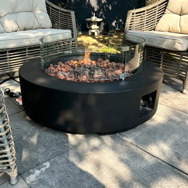 Round Gas Fire Pit Table with Lava Rock and Glass Screen in black — in a room setting