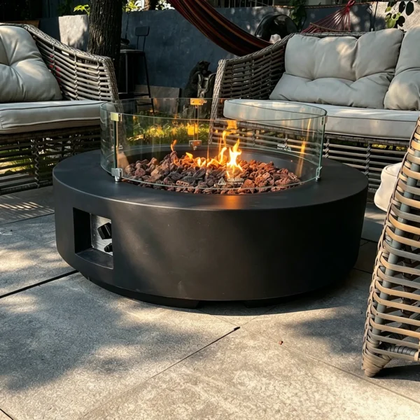 Round Gas Fire Pit Table with Lava Rock and Glass Screen in black — in a room setting