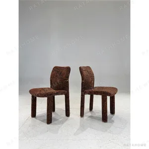 Geometric Pattern Upholstered Dining Chair with Brass Detail in rust — in a room setting