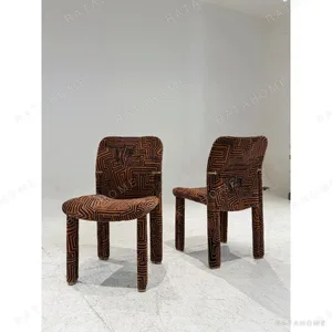 Geometric Pattern Upholstered Dining Chair with Brass Detail in rust — in a room setting