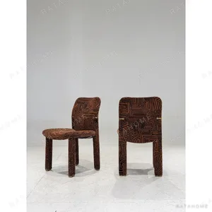 Geometric Pattern Upholstered Dining Chair with Brass Detail in rust — in a room setting