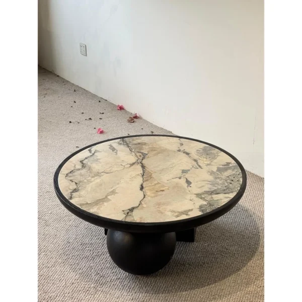 Round Ink Jade Marble Coffee Table on Black Sphere Base in black — in a room setting
