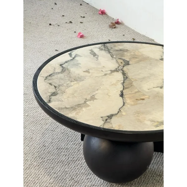 Round Ink Jade Marble Coffee Table on Black Sphere Base in black — in a room setting