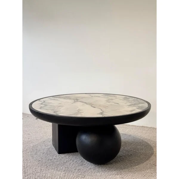Round Ink Jade Marble Coffee Table on Black Sphere Base in black — in a room setting