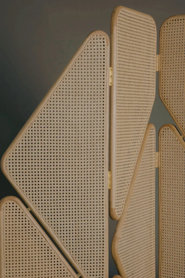 Geometric Cane Panel Folding Screen with Aged Hinges in natural oak — in a room setting