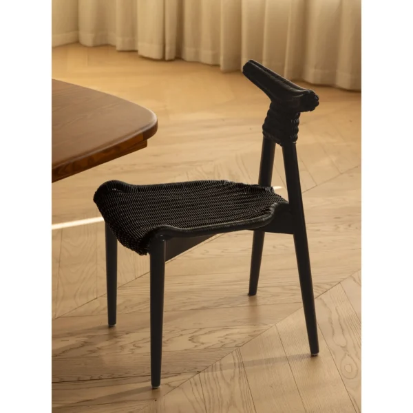 Goat Horn Black Teak Chair with Woven Rattan Seat in black — in a room setting