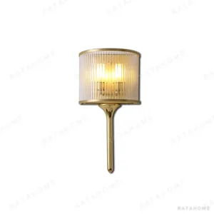 Brass Rod Wall Light with Ribbed Glass Drum Shade in brushed brass — in a room setting