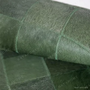 Green Cowhide Round Rug with Geometric Patchwork in olive — in a room setting