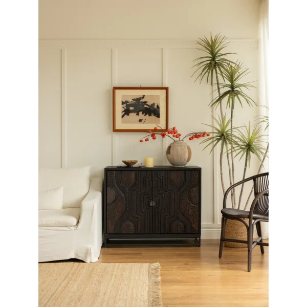 Hand-Carved Totem Door Teak Cabinet on Black Metal Base in black — in a room setting