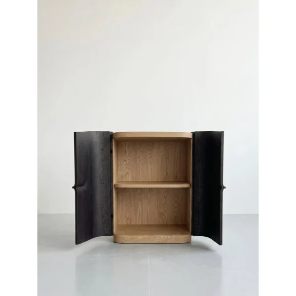 Hand-Carved Black Oak Sculptural Cabinet with Recessed Pull in black — in a room setting