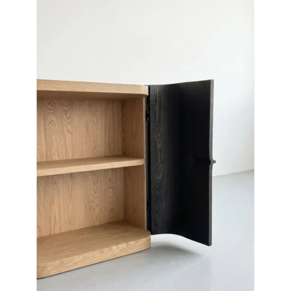 Hand-Carved Black Oak Sculptural Cabinet with Recessed Pull in black — in a room setting