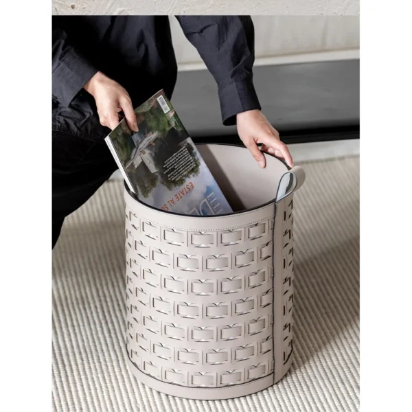 Hand-Woven Orange Leather Laundry Basket with Handles in rust — in a room setting