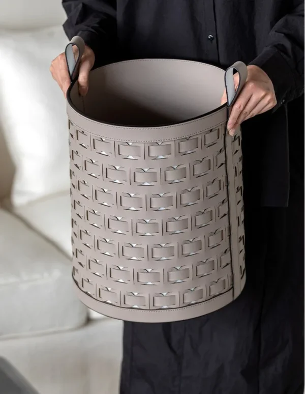 Hand-Woven Orange Leather Laundry Basket with Handles in rust — in a room setting