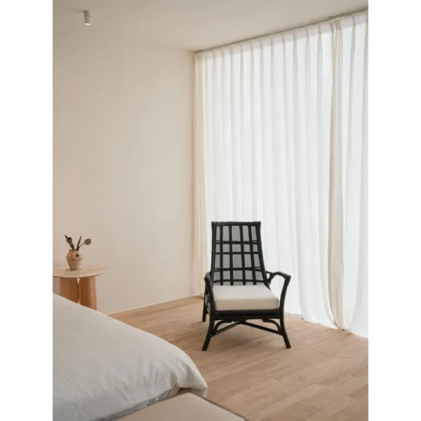 Harper Black Rattan Lounge Chair in black — in a room setting