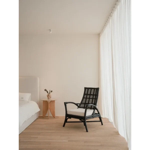 Harper Black Rattan Lounge Chair in black — in a room setting