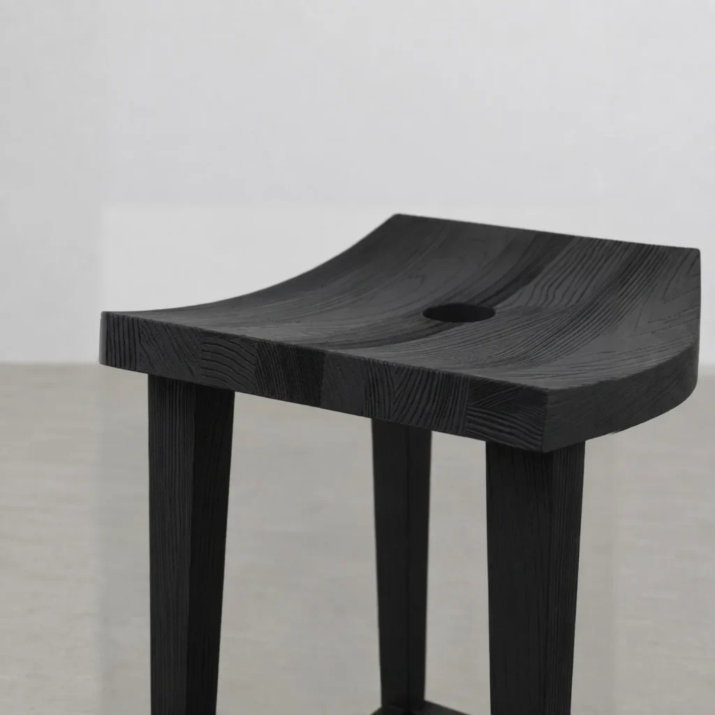 Charred Black Oak Saddle Stool in black — front view