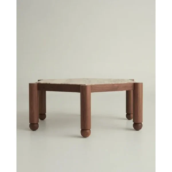 Hexagonal Travertine Coffee Table on Walnut Ball-Foot Legs in sand — in a room setting