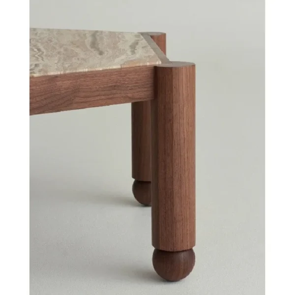 Hexagonal Travertine Coffee Table on Walnut Ball-Foot Legs in sand — in a room setting