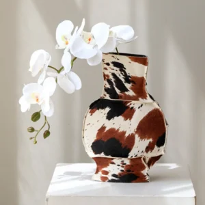 Cowhide-Wrapped Ceramic Vase in Black and Brown Spots — front view