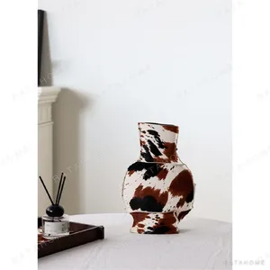Cowhide-Wrapped Ceramic Vase in Black and Brown Spots — in a room setting