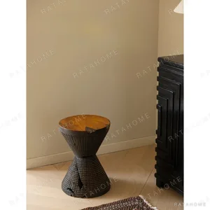 Hourglass Carved Teak Stool with Natural Hollows in clay — in a room setting
