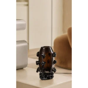 Hand-Made Amber Glass Vase with Black Studs in clay — in a room setting
