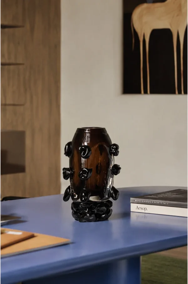 Hand-Made Amber Glass Vase with Black Studs in clay — in a room setting