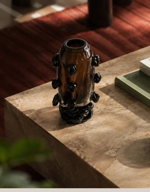 Hand-Made Amber Glass Vase with Black Studs in clay — in a room setting