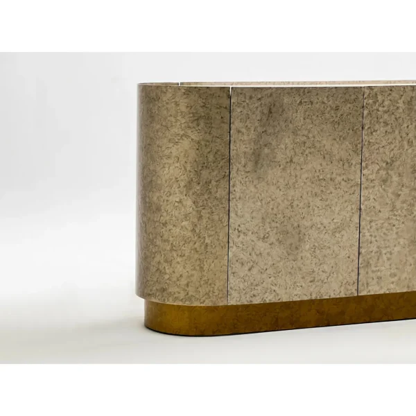 Mottled Stone-Finish Rounded Sideboard on Brass Plinth in sand — in a room setting