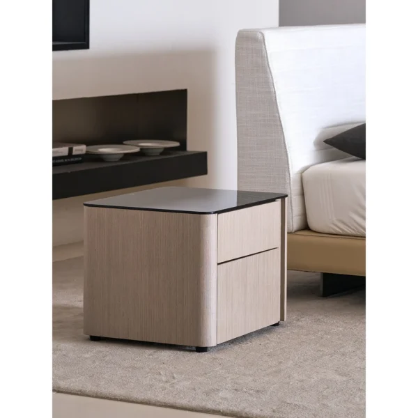 Rounded Oak Nightstand with Black Glass Top in natural oak — in a room setting