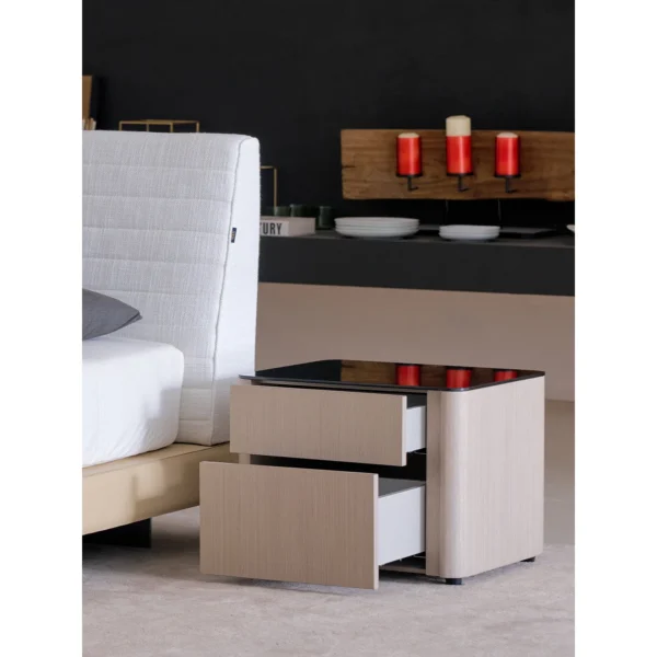 Rounded Oak Nightstand with Black Glass Top in natural oak — in a room setting