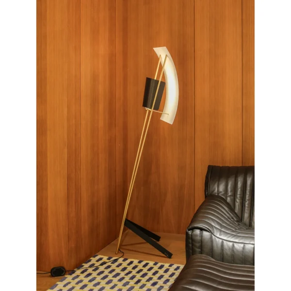 Kite Sculptural Floor Lamp with Perforated Curved Shade in brushed brass — in a room setting