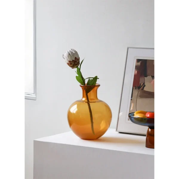 Glossy Coloured Glass Bottle Vases in Amber and Grass Green — in a room setting