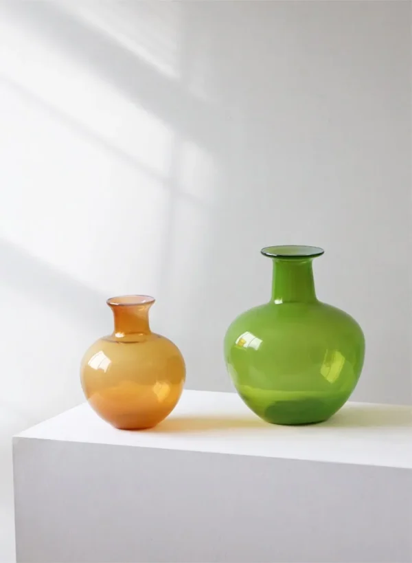 Glossy Coloured Glass Bottle Vases in Amber and Grass Green — in a room setting