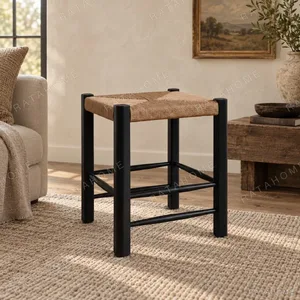Latitude Black Wood Stool with Woven Rattan Seat in black — in a room setting