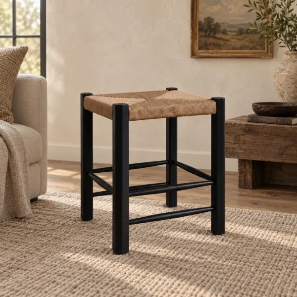Latitude Black Wood Stool with Woven Rattan Seat in black — in a room setting