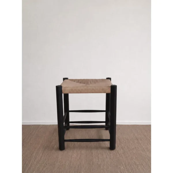 Latitude Black Wood Stool with Woven Rattan Seat in black — in a room setting