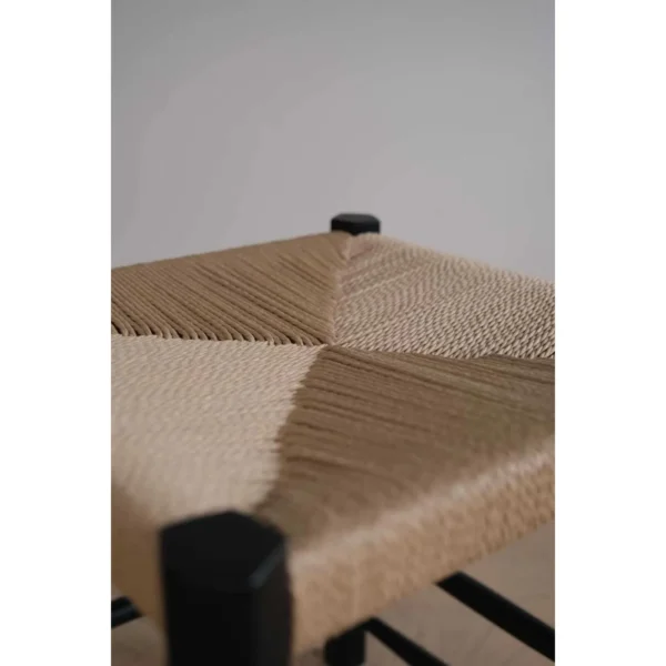 Latitude Black Wood Stool with Woven Rattan Seat in black — in a room setting