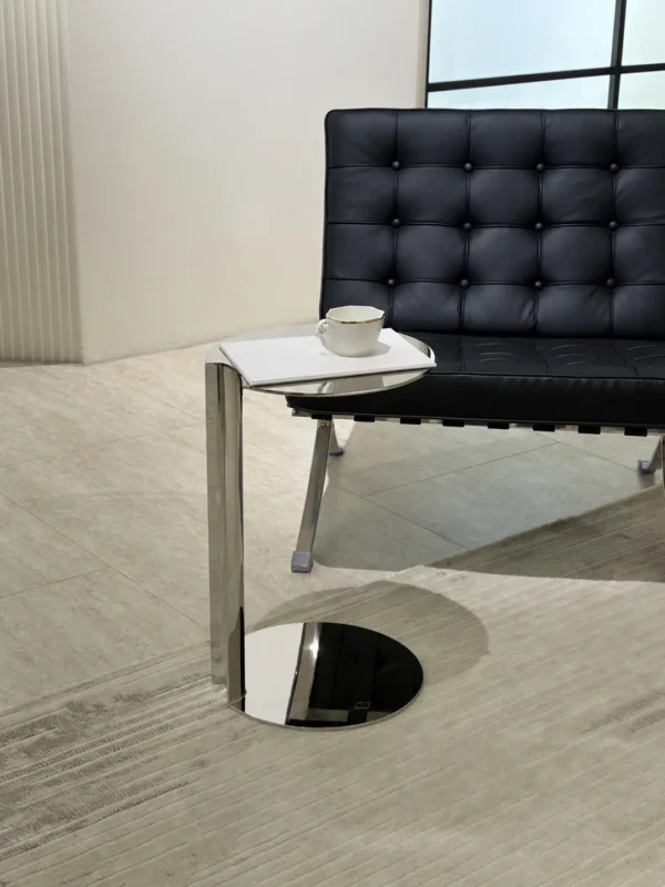 C-Shaped Mirror Steel Sofa Side Table in silver — in a room setting
