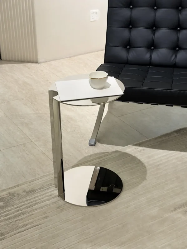 C-Shaped Mirror Steel Sofa Side Table in silver — in a room setting